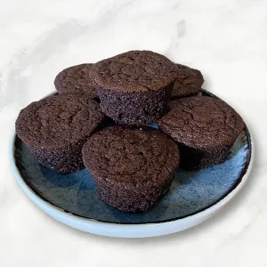 six Sip! Extraordinary Brownies on a blue ceramic plate on white marble table